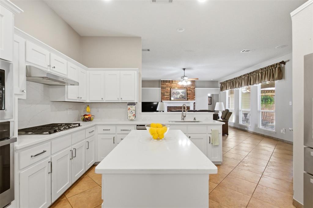 4218 Glistening Spring Rowlett, TX 75088 - Photo 12 of 39 White shaker cabinetry with an integrated gas range and stainless steel hood