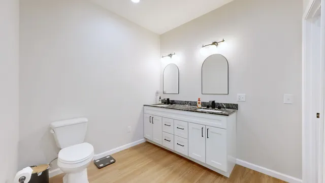 a bathroom with a toilet sink and mirror
