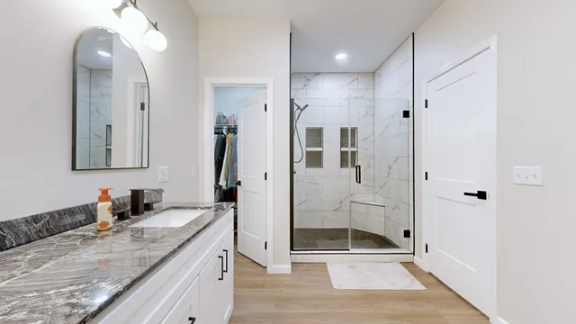 a spacious bathroom with a granite countertop sink mirror and shower