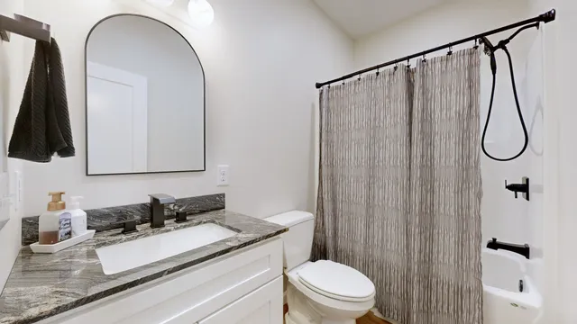 a bathroom with a granite countertop sink toilet and shower