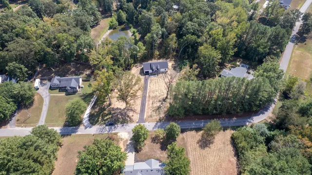 an aerial view of a house with a yard and lake view
