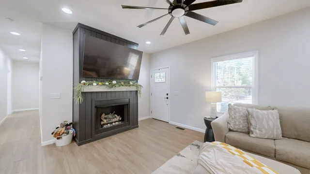 a living room with furniture a flat screen tv and a fireplace