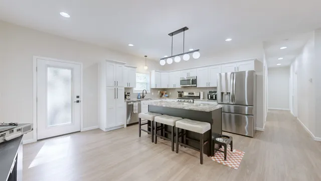 a kitchen with a dining table chairs refrigerator and cabinets