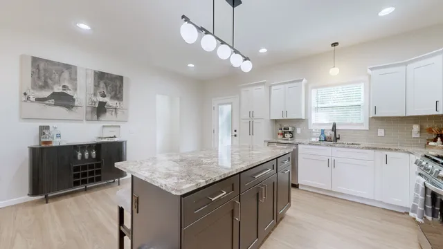 a kitchen with stainless steel appliances granite countertop a sink stove and refrigerator