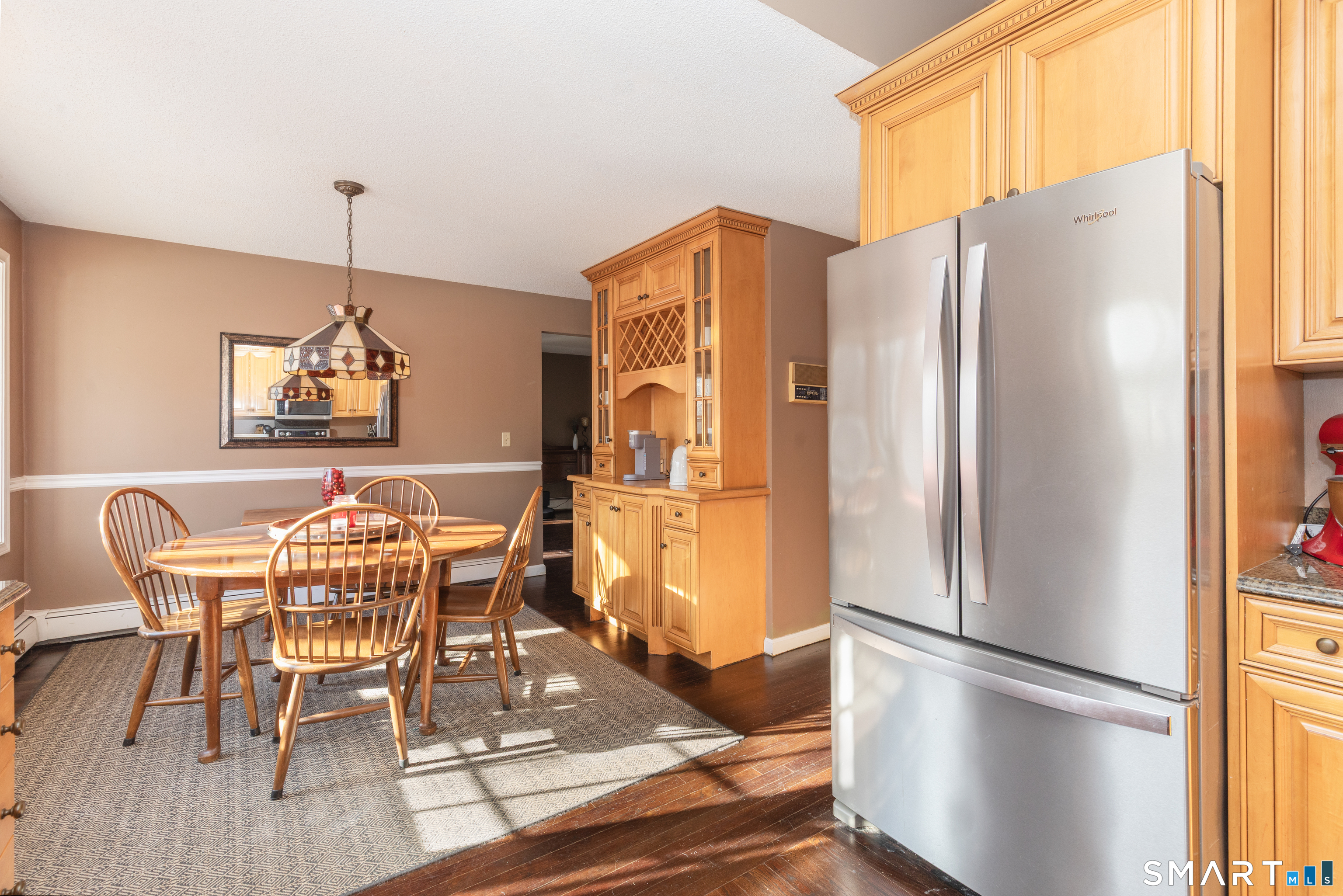 637 Watertown Road Middlebury, CT 06762 - Photo 9 of 40 a dining room with stainless steel appliances granite countertop a refrigerator a microwave a dining table and chairs with wooden floor
