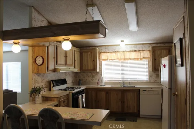 a kitchen with stainless steel appliances granite countertop a sink and a stove