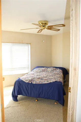 a bedroom with a bed and ceiling fan