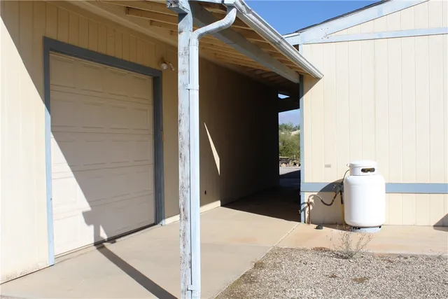 a view of a dry yard with wooden fence