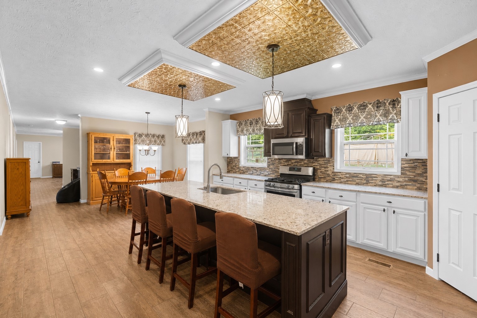 1800 2110th Road Hugo, OK 74743 - Photo 8 of 27 Kitchen featuring an island with stone-finish countertop, stainless steel appliances, dual-tone cabinetry, and wood-finish flooring
