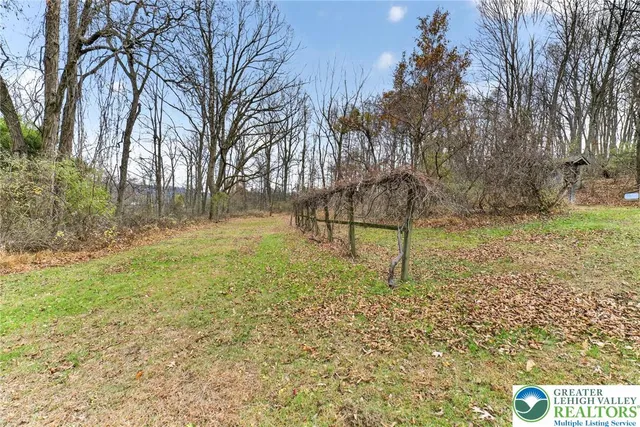 a view of a lake with a yard and large trees
