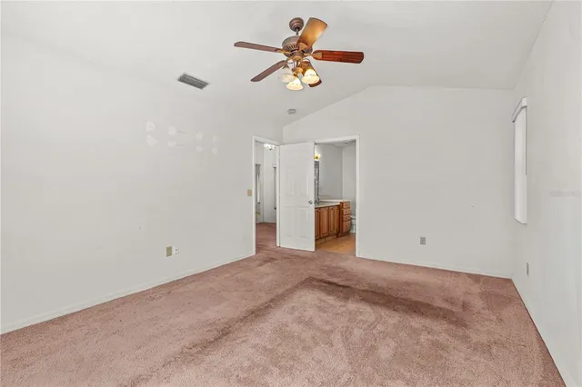 a view of a room with a ceiling fan and window