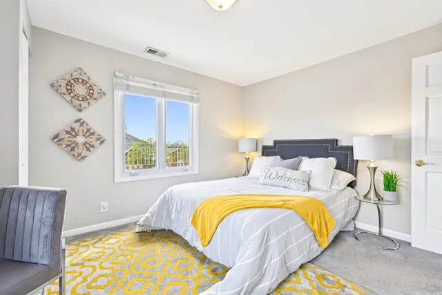 a bedroom with a bed lamp and a potted plant