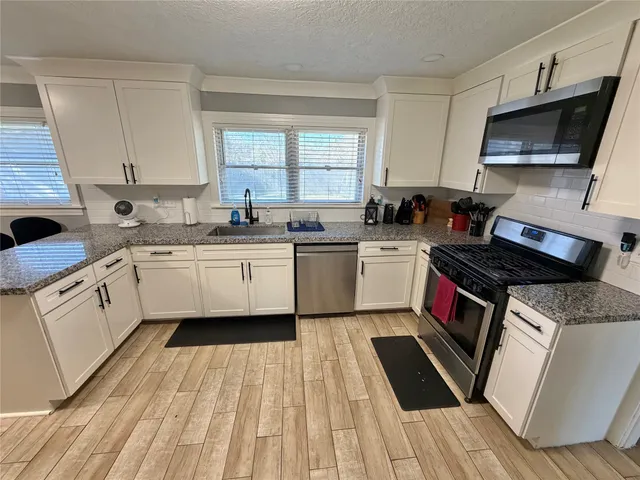 a kitchen with a sink stove top oven and cabinets