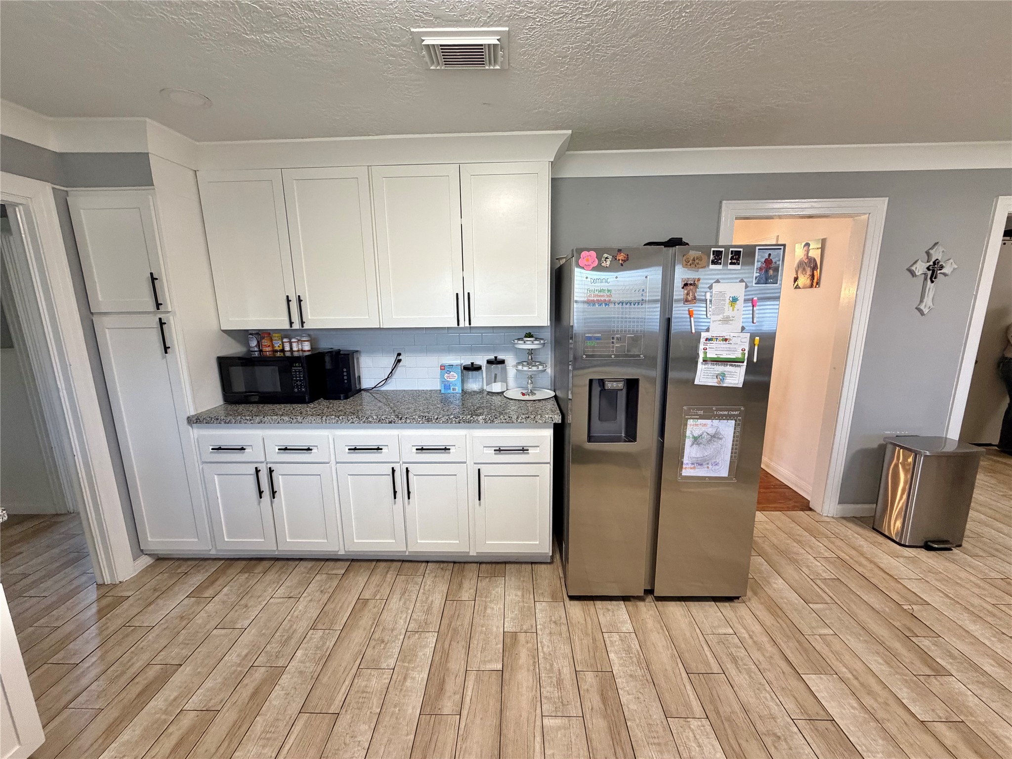 907 East Magnolia Street Angleton, TX 77515 - Photo 19 of 34 a kitchen with stainless steel appliances granite countertop a refrigerator a stove and a sink with wooden floor
