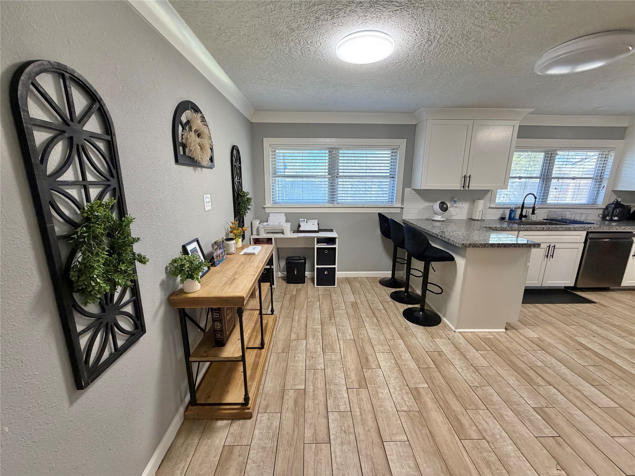 907 East Magnolia Street Angleton, TX 77515 - Photo 22 of 34 a kitchen with stainless steel appliances a dining table chairs stove refrigerator and cabinets
