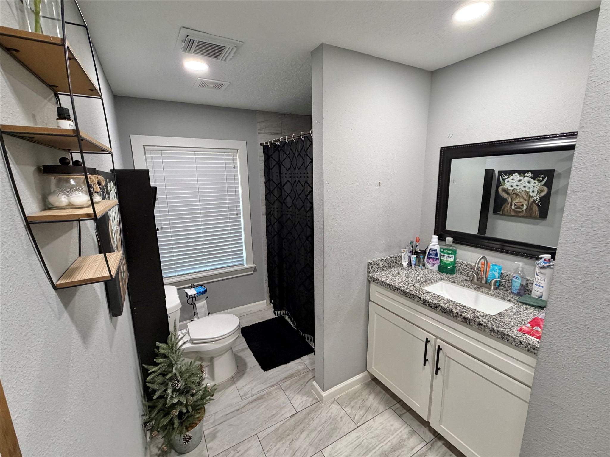 907 East Magnolia Street Angleton, TX 77515 - Photo 25 of 34 a bathroom with a sink and a mirror