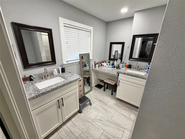 a bathroom with a sink double vanity granite and a mirror
