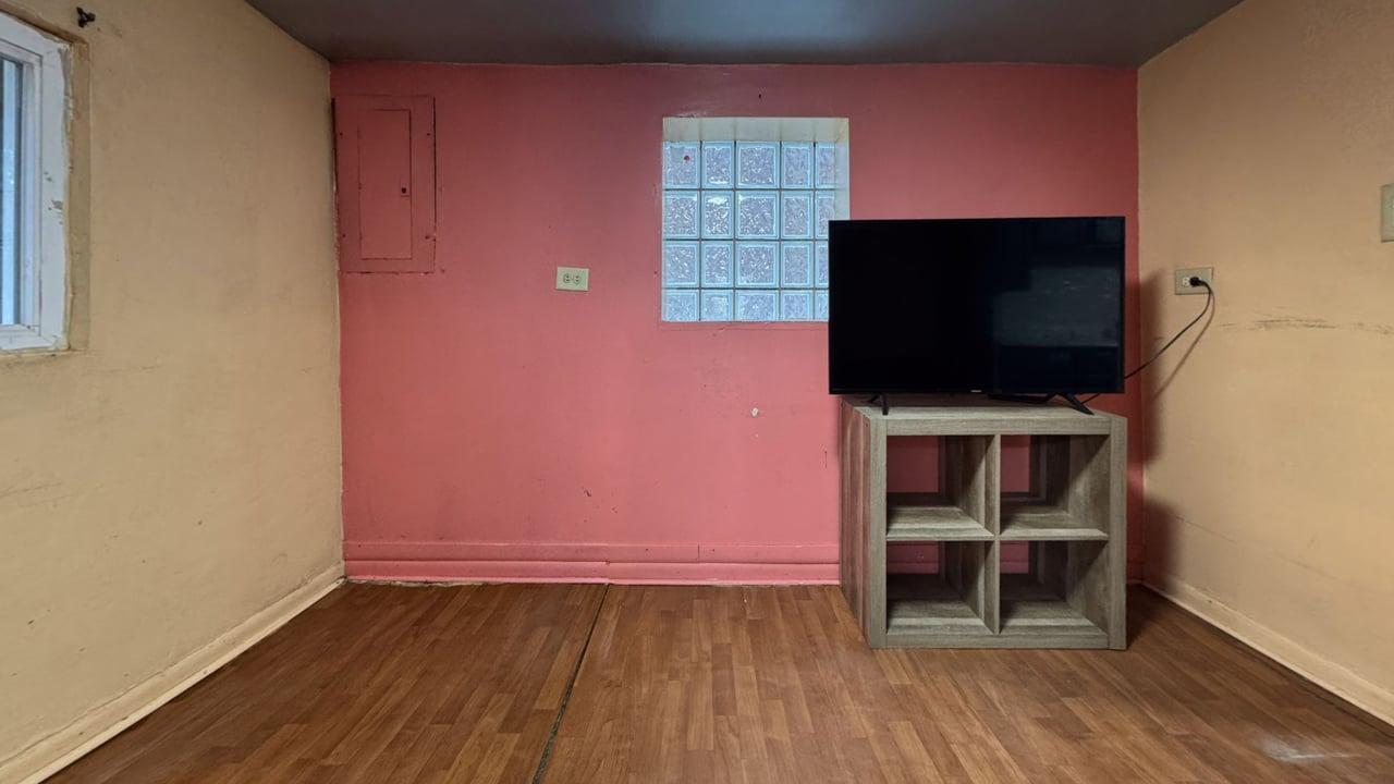 1041 North Ridgeway Avenue Chicago, IL 60651 - Photo 26 of 33 a room with wooden floor and a flat screen tv