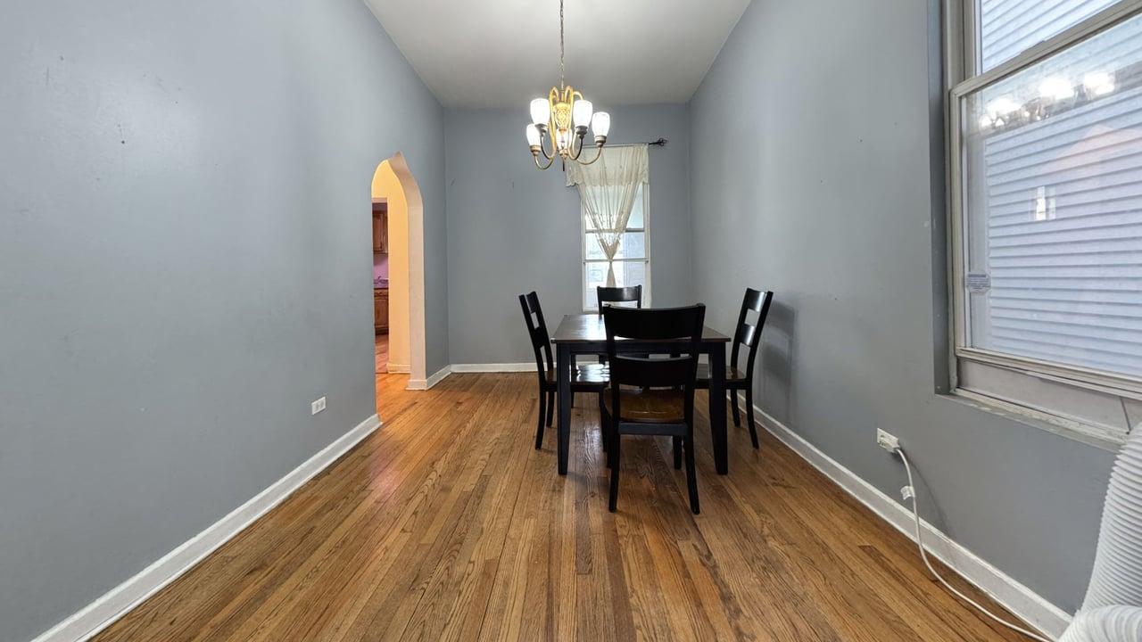 1041 North Ridgeway Avenue Chicago, IL 60651 - Photo 7 of 33 a dining room with chandelier and wooden floor