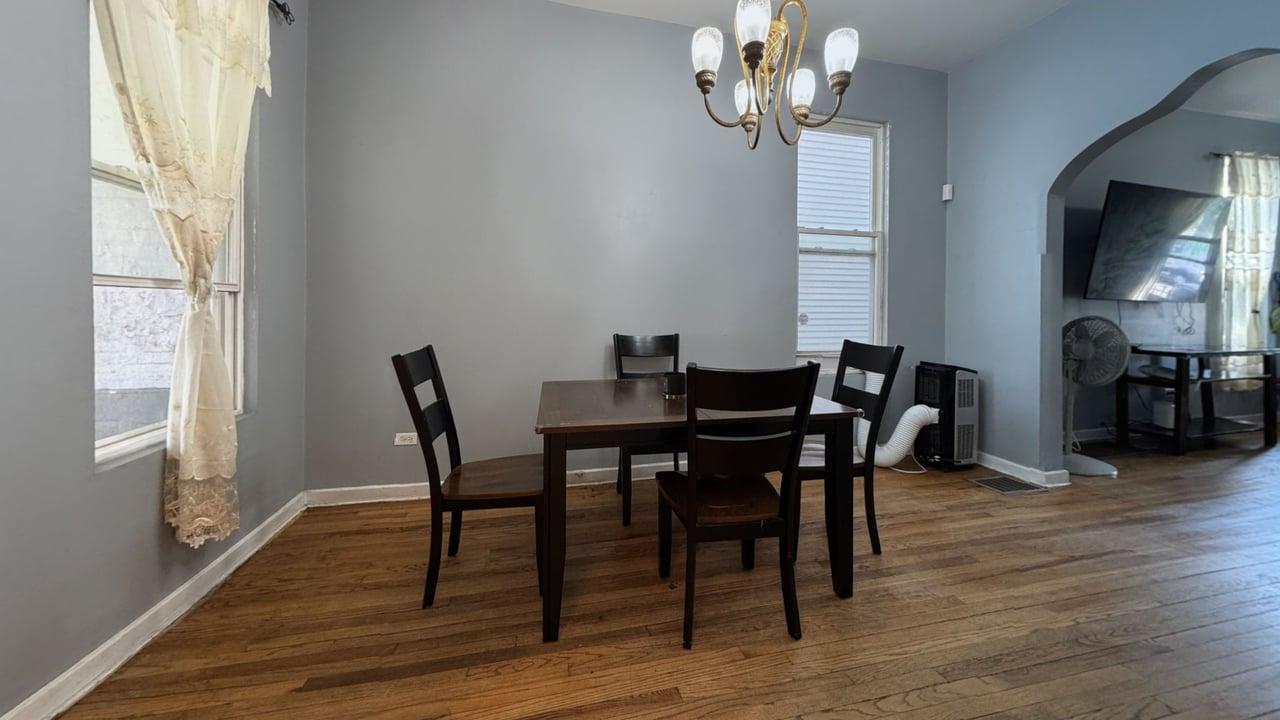 1041 North Ridgeway Avenue Chicago, IL 60651 - Photo 9 of 33 a view of a dining room with furniture a chandelier and wooden floor