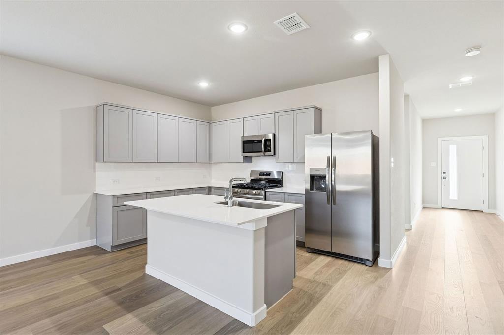 1156 Del Rio Drive Lavon, TX 75166 - Photo 6 of 35 a kitchen with wooden cabinets and stainless steel appliances
