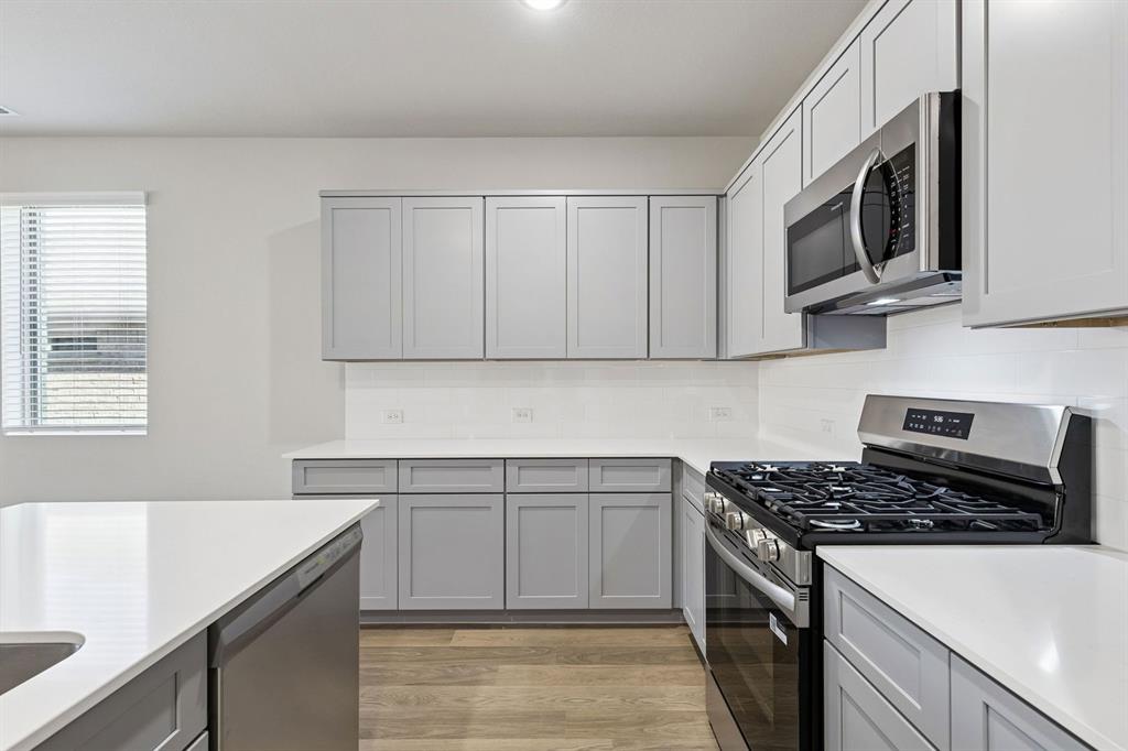 1156 Del Rio Drive Lavon, TX 75166 - Photo 8 of 35 a kitchen with stainless steel appliances granite countertop a sink stove and microwave