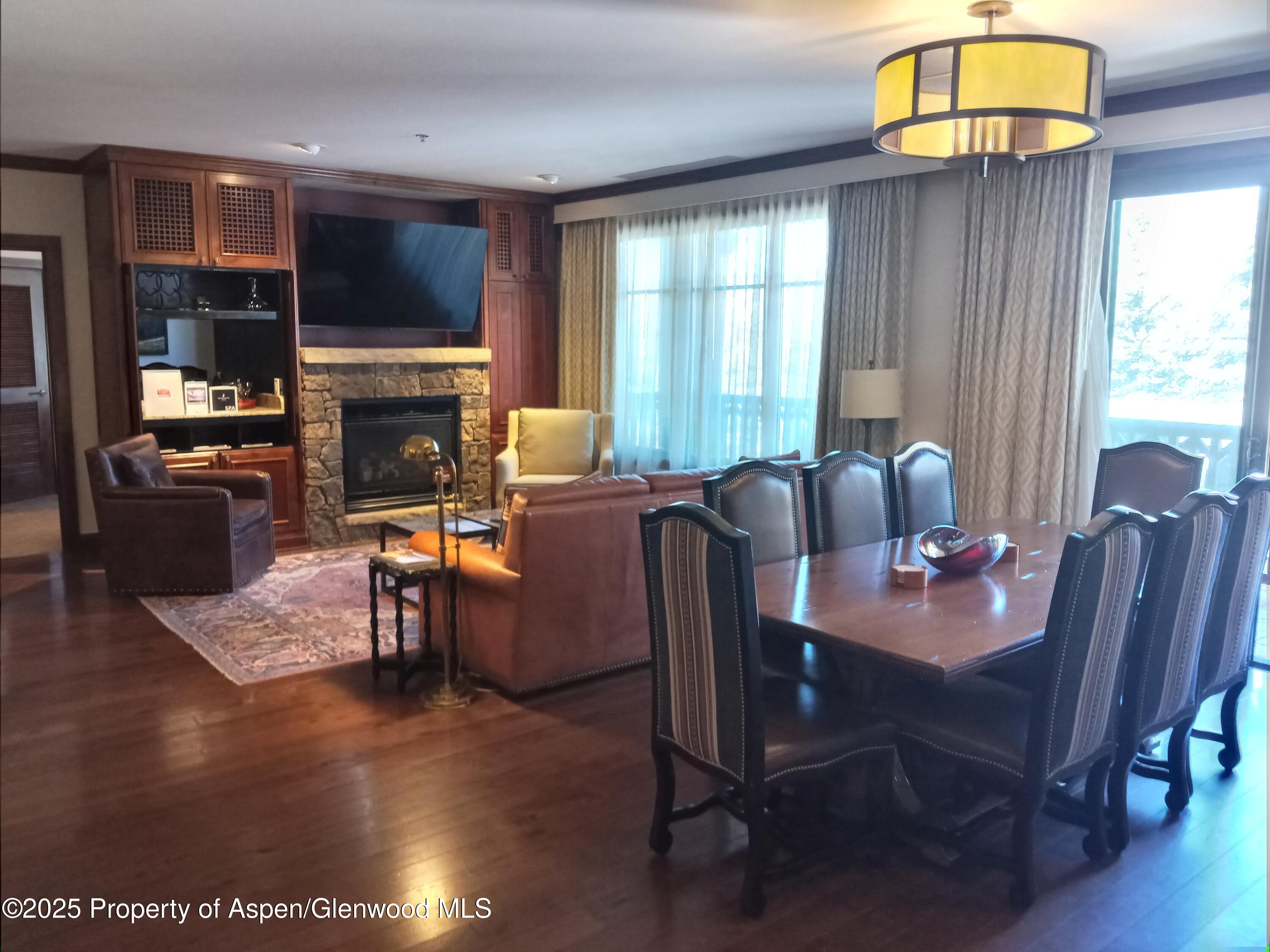 197 Prospector Road, Unit 2312 FIXED WEEKS 1 34 35 Aspen, CO 81611 - Photo 32 of 38 a dining room with furniture a fireplace and wooden floor