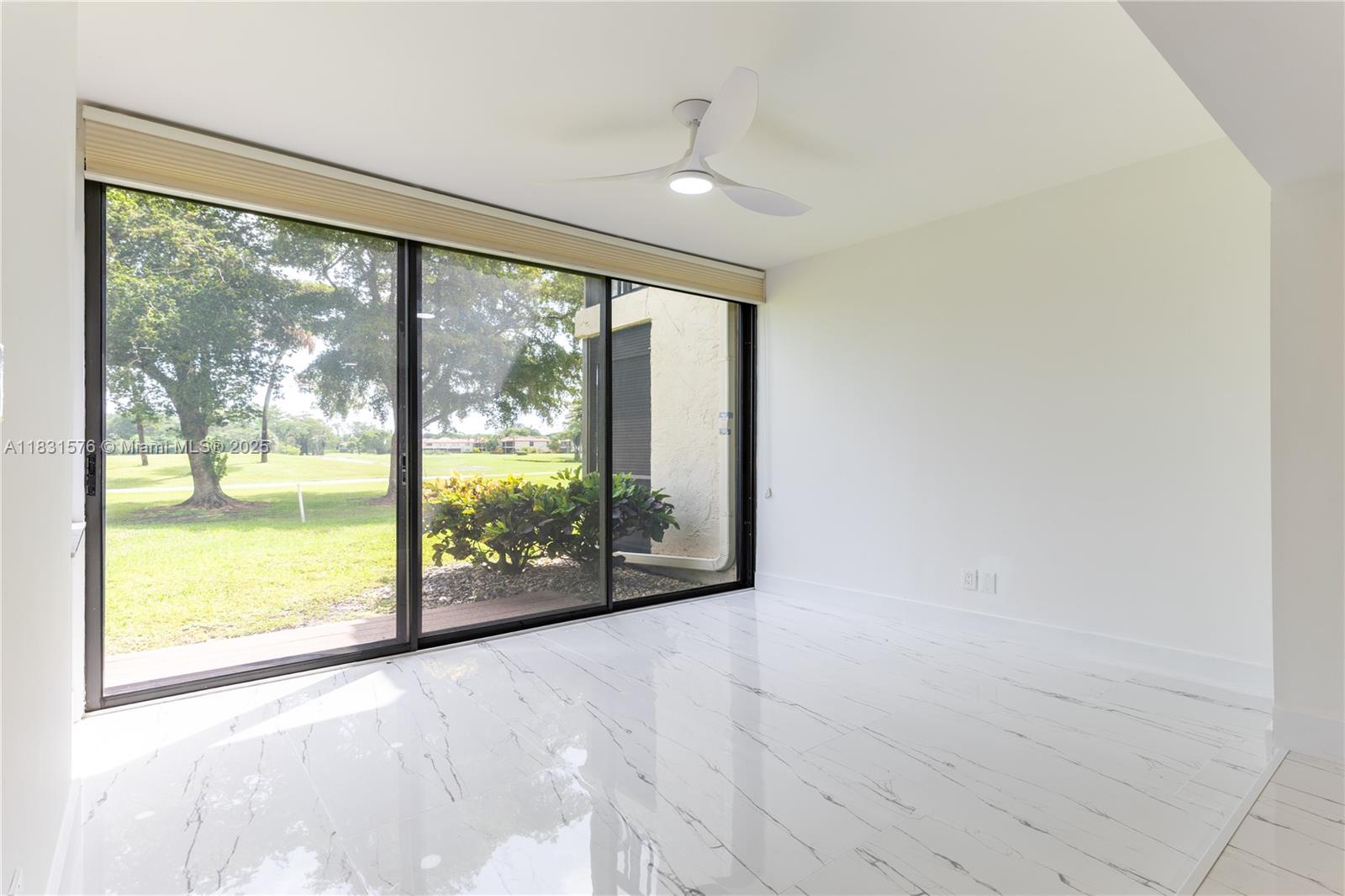 8435 Casa Del Lago, Unit 22C Boca Raton, FL 33433 - Photo 20 of 55 a view of an empty room with wooden floor and a large window