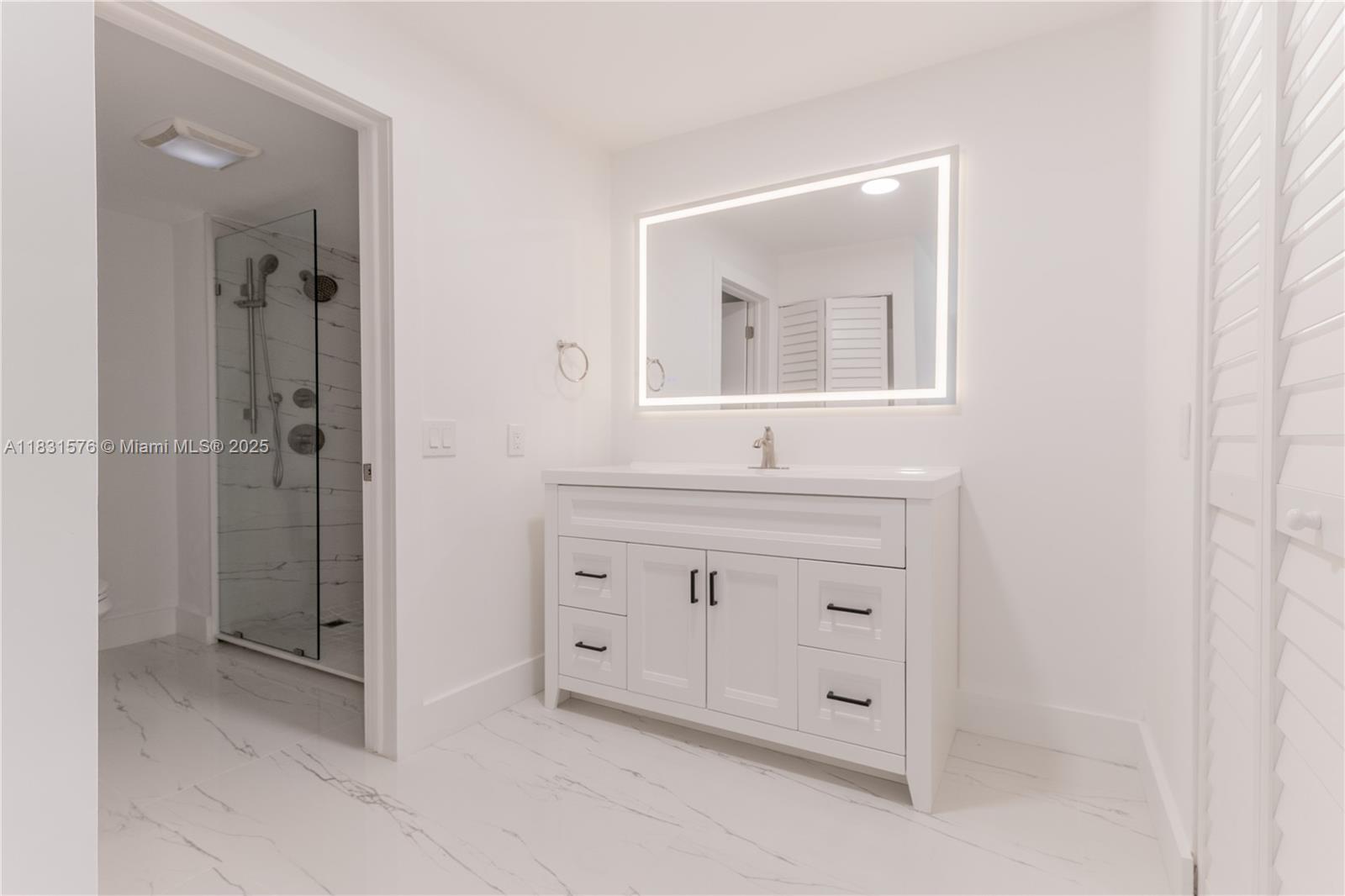 8435 Casa Del Lago, Unit 22C Boca Raton, FL 33433 - Photo 27 of 55 a bathroom with a sink vanity and mirror