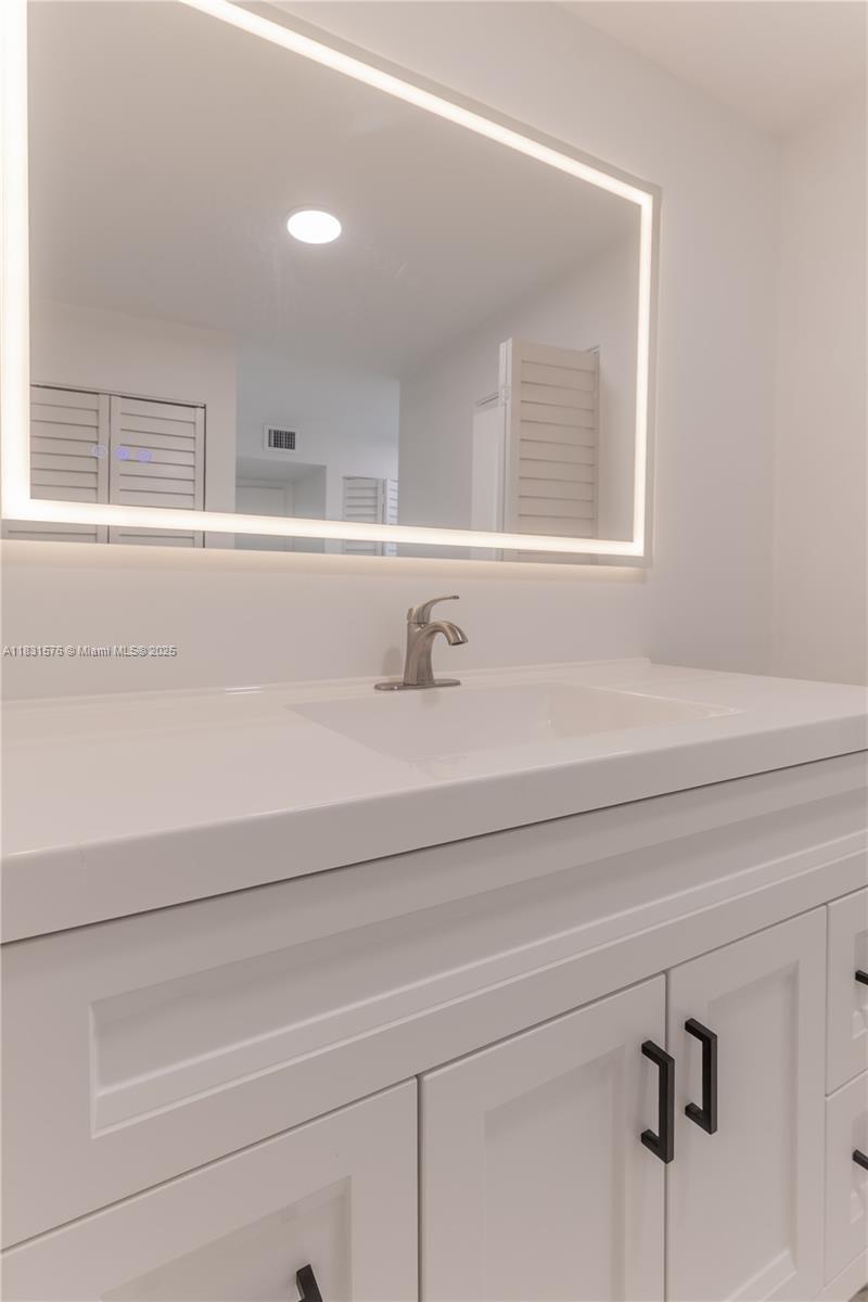 8435 Casa Del Lago, Unit 22C Boca Raton, FL 33433 - Photo 33 of 55 a bathroom with a sink and a mirror