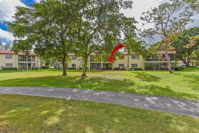 an aerial view of a houses with a garden and lake view