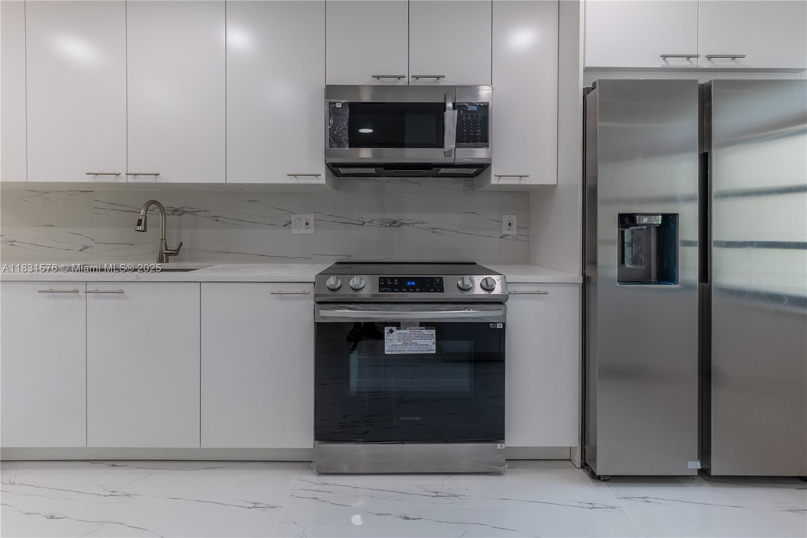 8435 Casa Del Lago, Unit 22C Boca Raton, FL 33433 - Photo 7 of 55 a kitchen with stainless steel appliances granite countertop a stove and a microwave