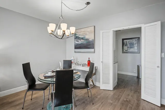 a kitchen with a refrigerator a stove and a sink with wooden floor