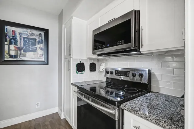 a kitchen with white cabinets sink and stainless steel appliances