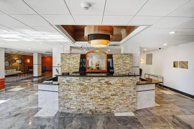 a large kitchen with stainless steel appliances kitchen island granite countertop a sink and a refrigerator