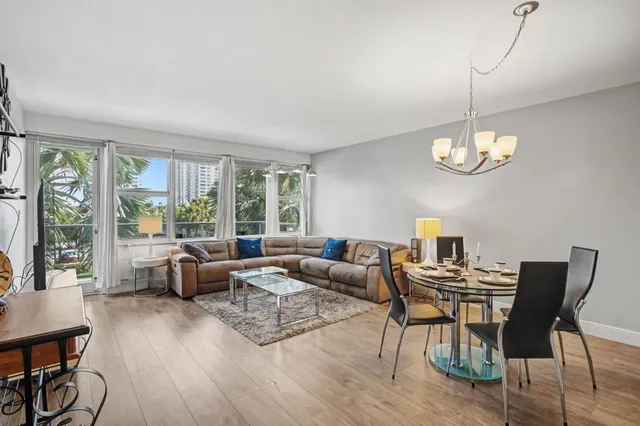 a living room with furniture a flat screen tv and a large window