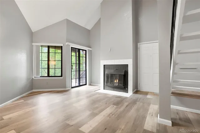 a view of an empty room with a window and fireplace