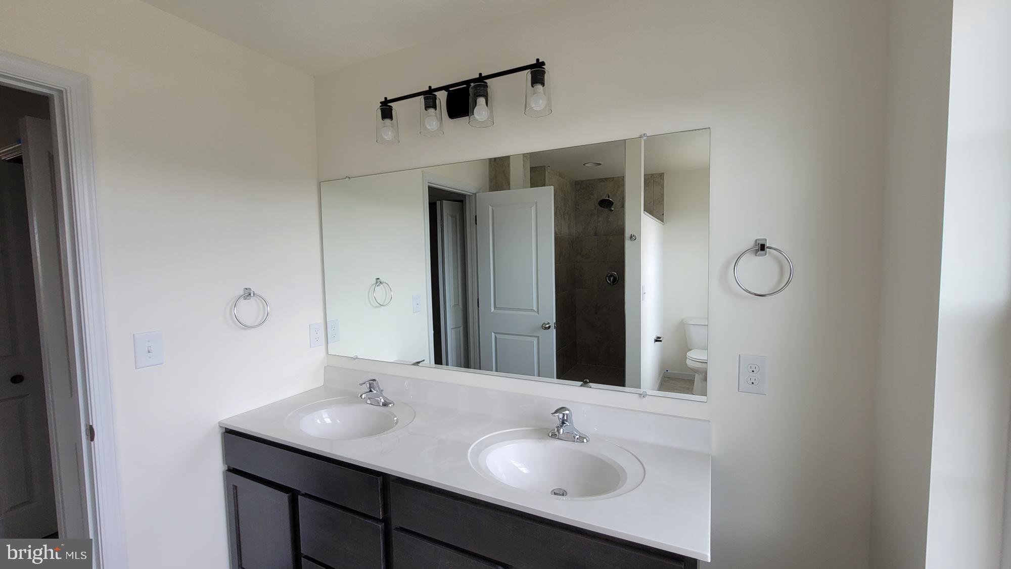 280 Ledger Drive, Unit 140 Hanover, PA 17331 - Photo 20 of 22 a bathroom with a shower sink vanity and mirror