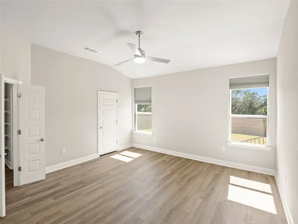 a large white kitchen with wooden floor and a sink