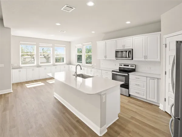 a kitchen with stainless steel appliances a microwave a sink and refrigerator
