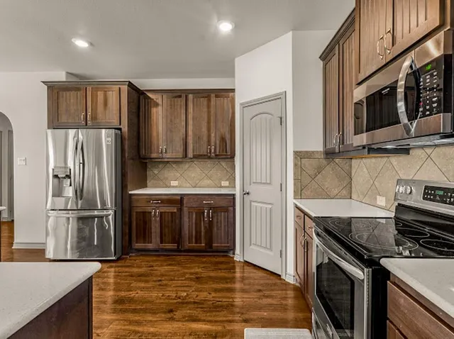 a kitchen with stainless steel appliances granite countertop a sink and stove top oven