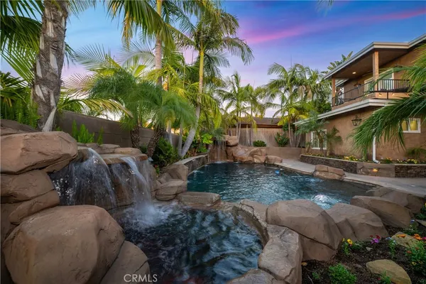 a view of swimming pool with a table and chairs under an umbrella