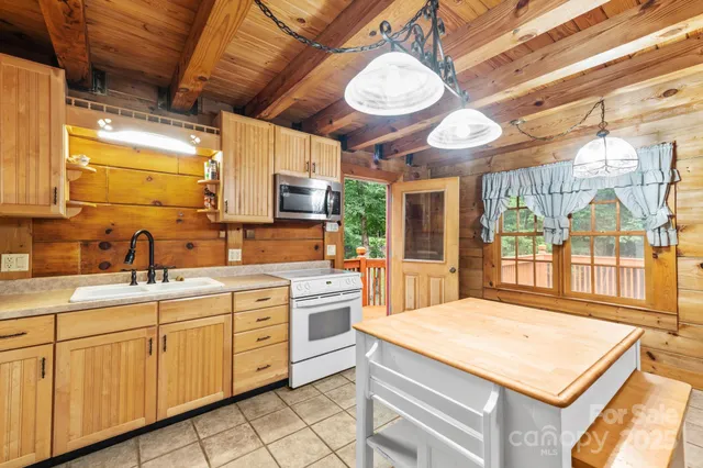 a kitchen with kitchen island granite countertop a sink a counter space appliances and cabinets