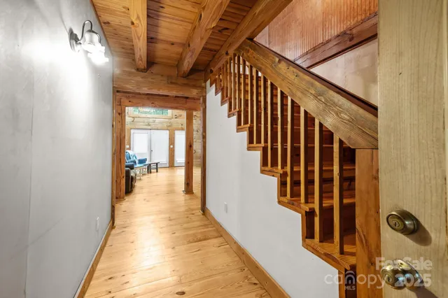 a view of a hallway with wooden floor and staircase
