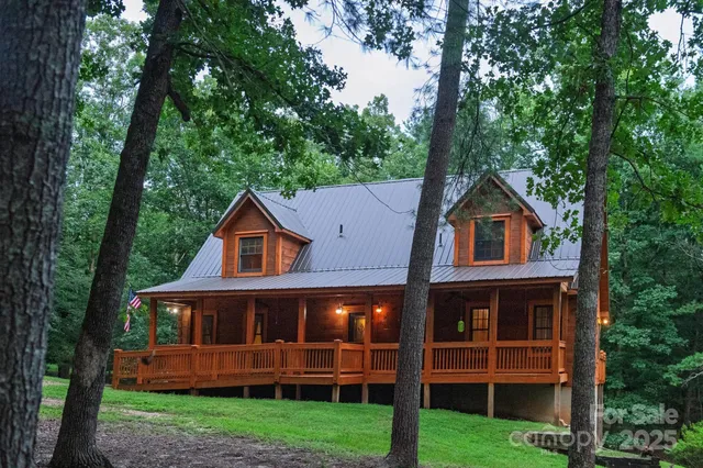 a front view of a house with a yard and large trees