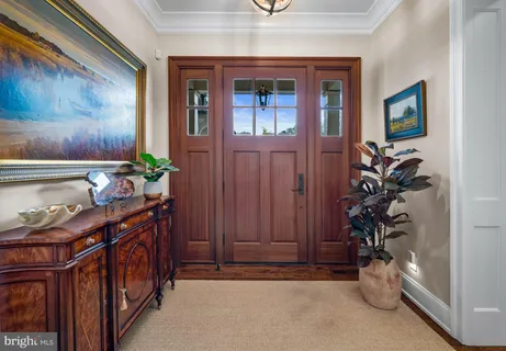 a view of a hallway with wooden floor and a bathroom