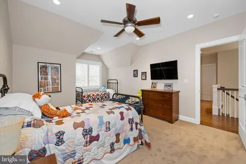 a spacious bedroom with a bed and wooden floor