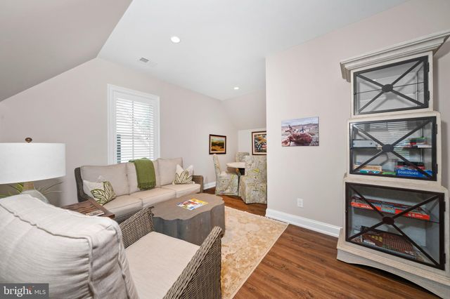 a view of a hallway with wooden floor and a living room