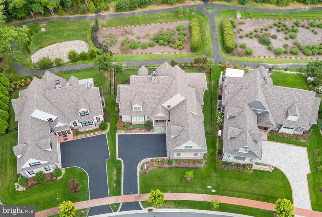 an aerial view of a house with a garden and lake view