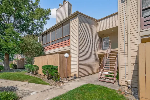 a view of a house with backyard and a tree